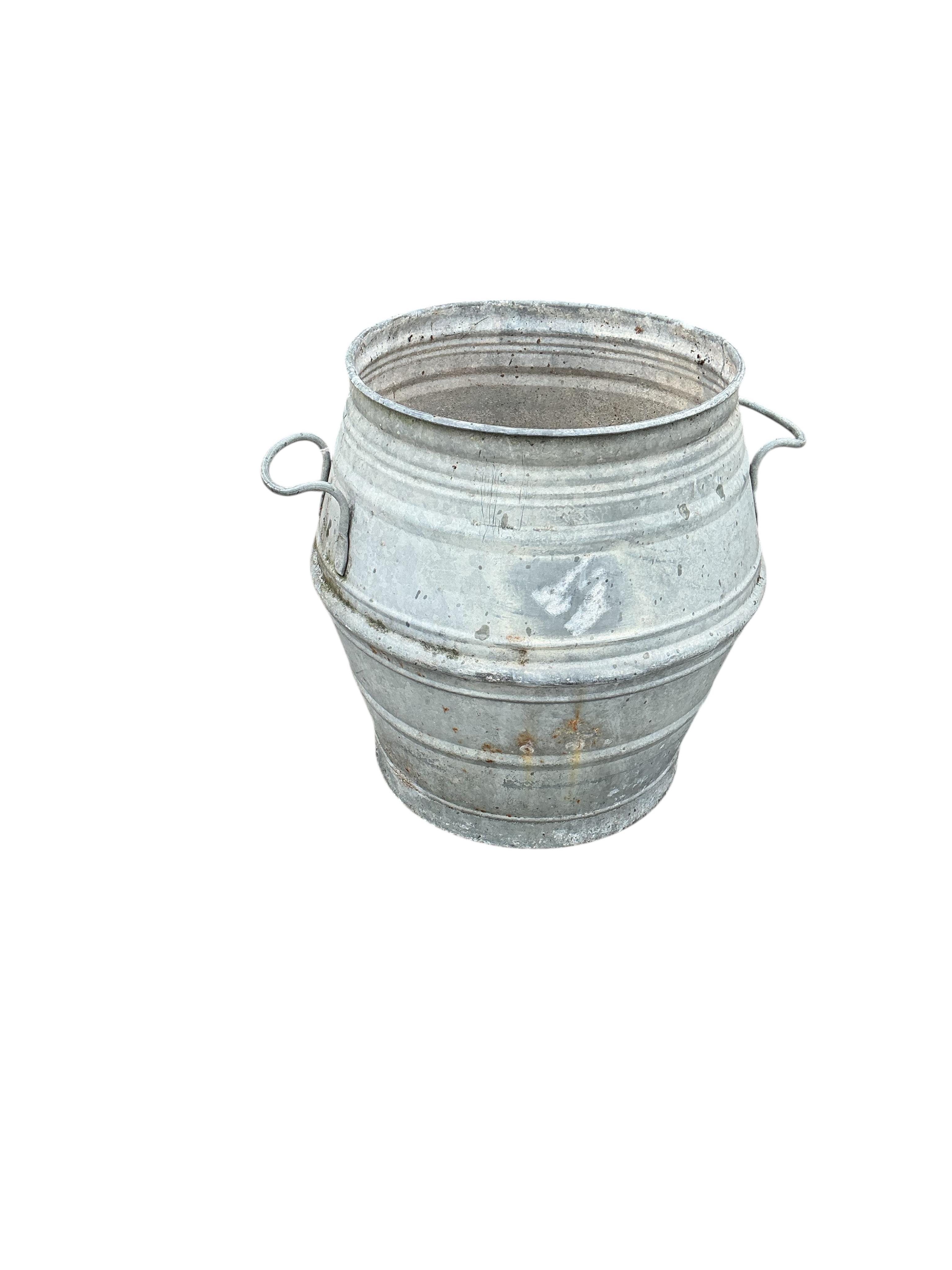 A near pair of circular galvanised metal barrels, diameter 46cm, height 52cm
